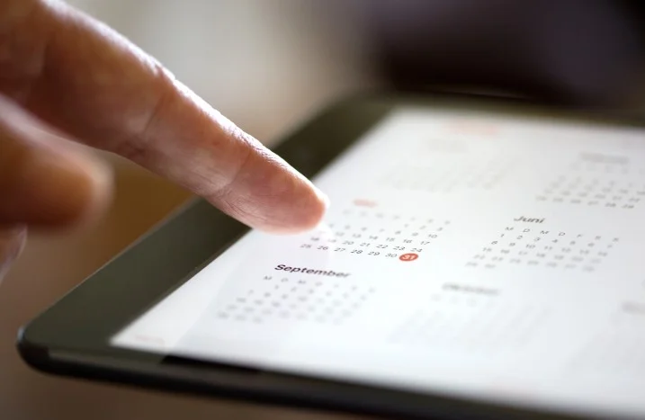 Finger tippt auf Tablet-Kalender